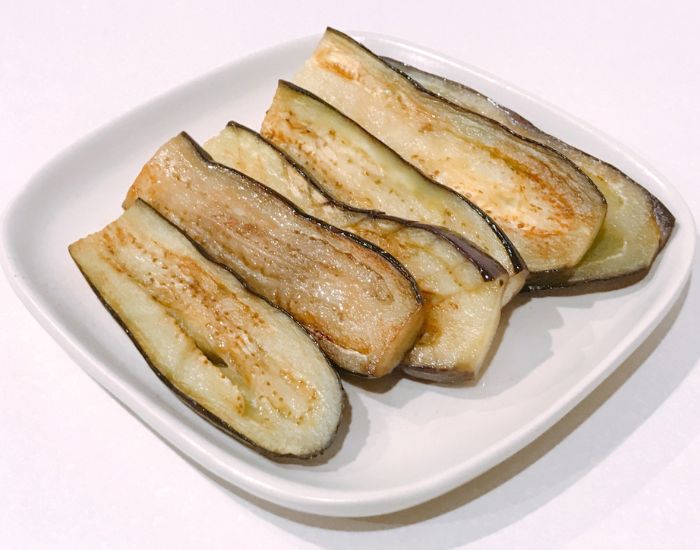 薄切りのナスを焼いて皿に盛りつけた様子