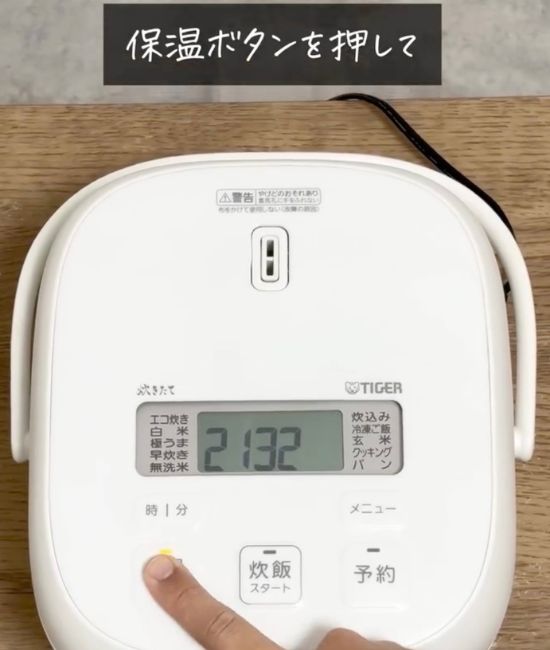 炊飯器の保温ボタンを押す様子