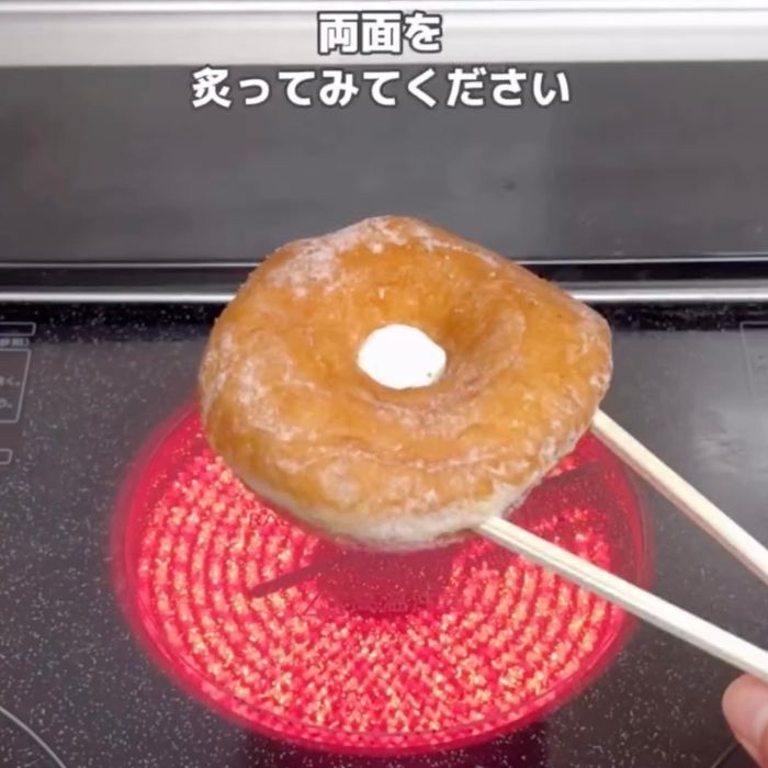 穴にマシュマロを入れた『シュガーレイズド』に割り箸を刺してあぶり焼きする様子