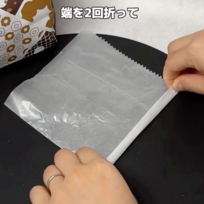 『2つ折りになった状態』の包み紙の端を2回折る様子