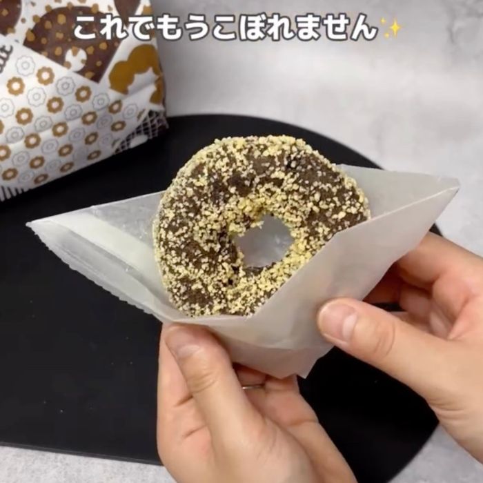 三角に折りたたんだ包み紙で『ゴールデンチョコレート』を持った様子