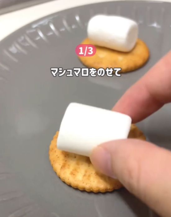 クラッカーの上にマシュマロをのせる様子