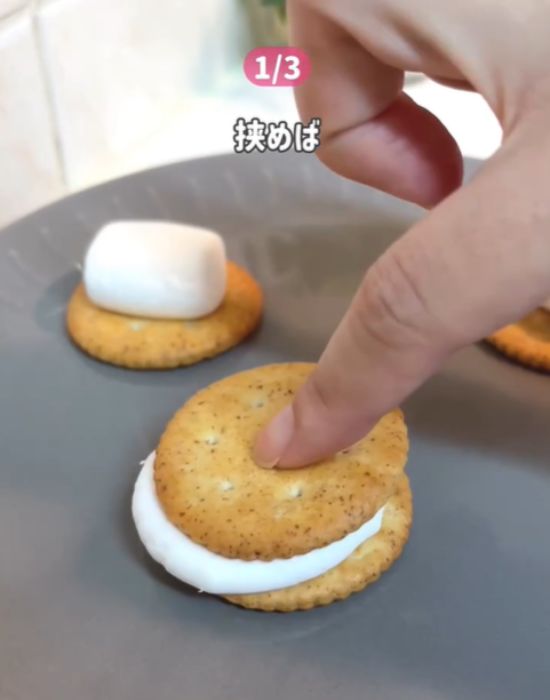 クラッカーとマシュマロの上にクラッカーをのせる様子
