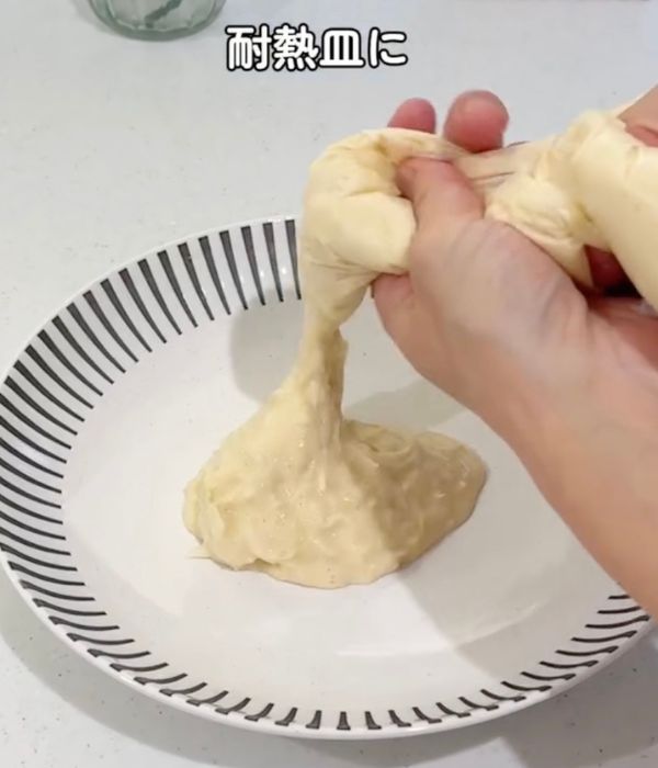 お好み焼きの生地の入ったビニール袋から生地を皿に出す様子