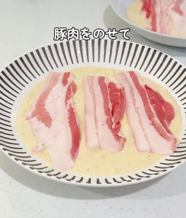 耐熱皿に出した生地の上に豚肉を並べて置いた様子
