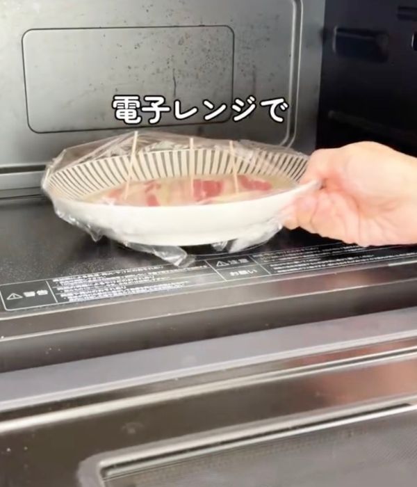 お好み焼きの生地を入れた耐熱皿を電子レンジに入れる様子