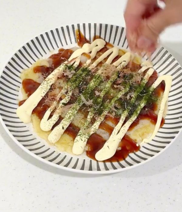 電子レンジで作ったお好み焼きにかつお節をのせる様子