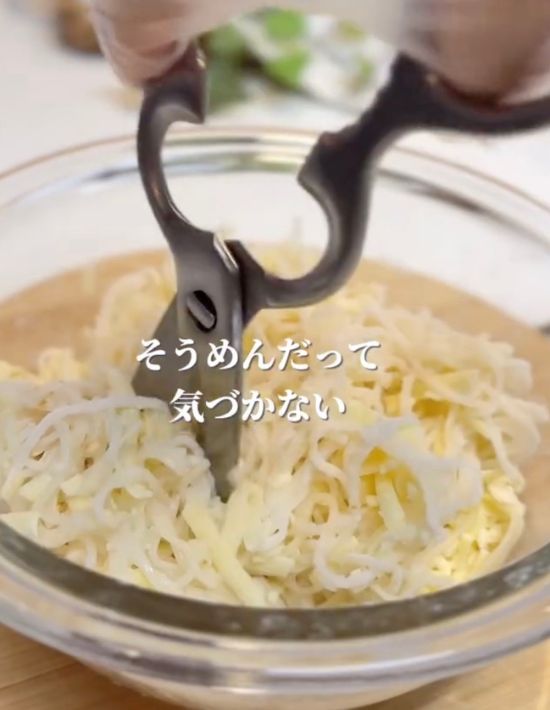 ボウルに入ったそうめんをキッチンばさみで切る様子