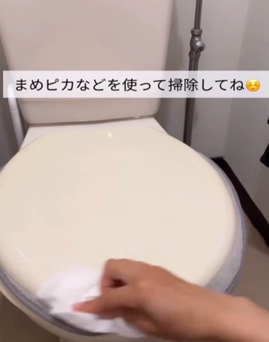 トイレットペーパーで便座を拭く様子