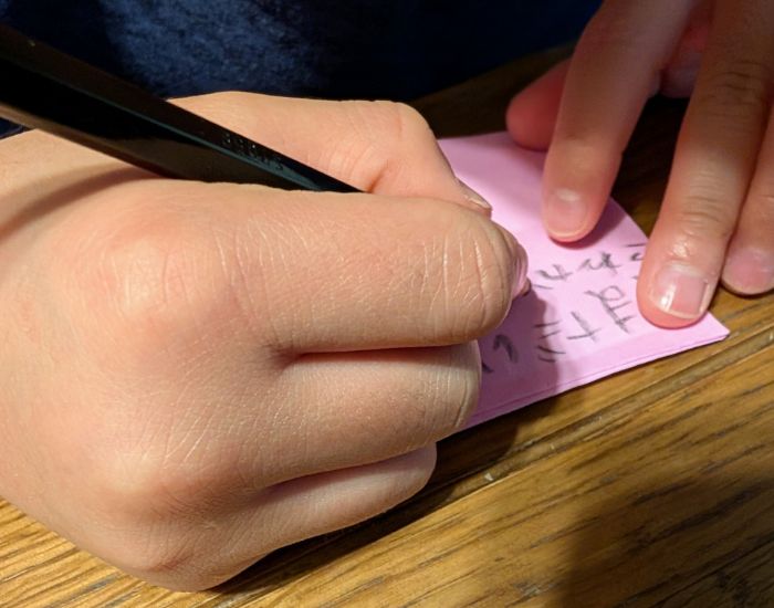 子供が鉛筆で手紙を書いている様子