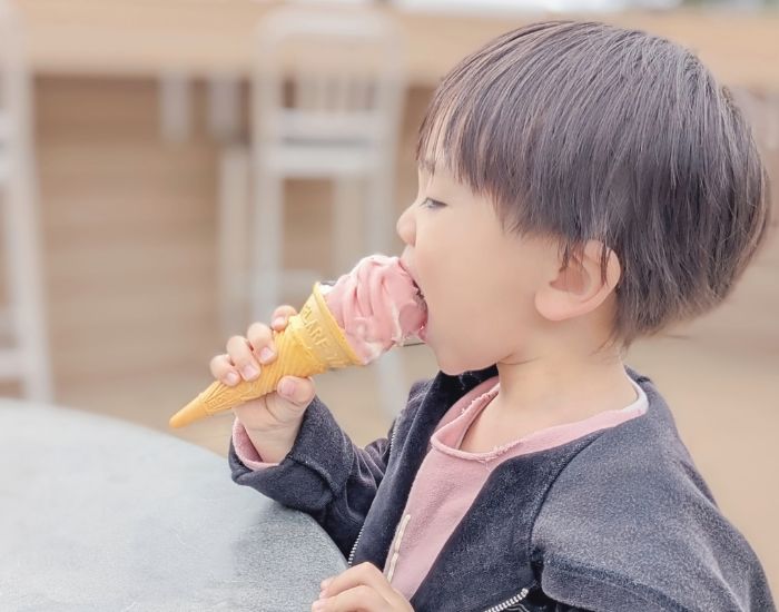 子供がコーンのアイスを食べている様子