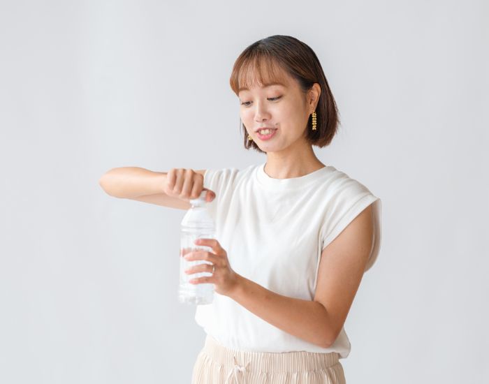 女性がペットボトルを開けようとしている様子
