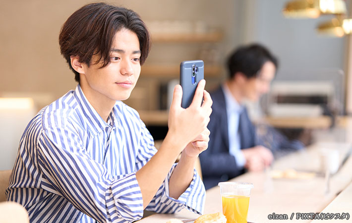 スマホを見る男性の写真