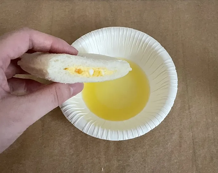 バター風味のオイルにサンドイッチを浸す