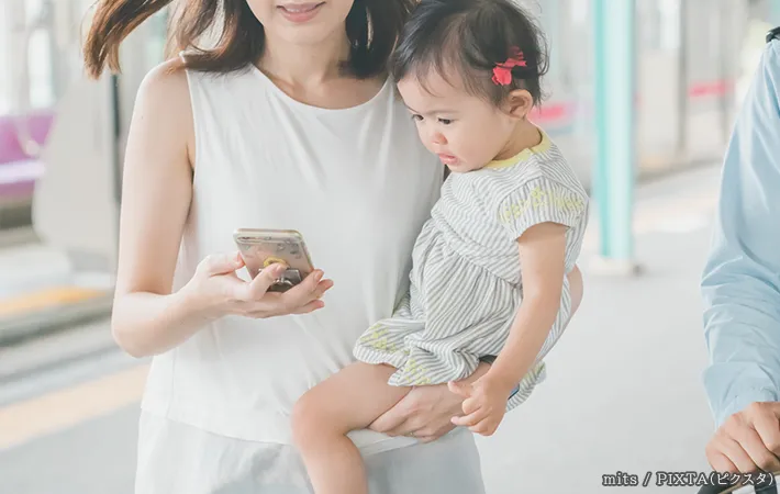 スマホを見る女性と子供の写真
