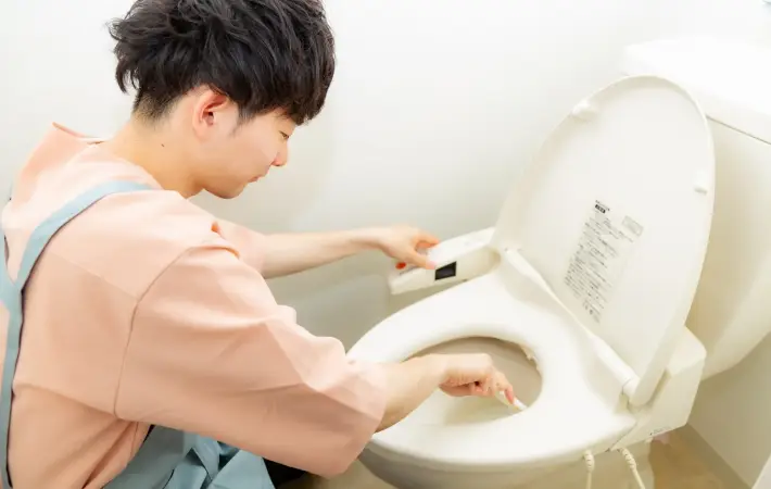 トイレ掃除をしている男性