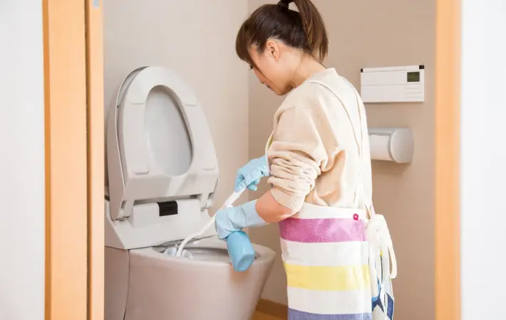 トイレ掃除をしている女性