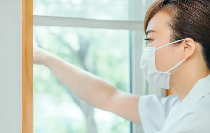 窓の掃除をしている女性