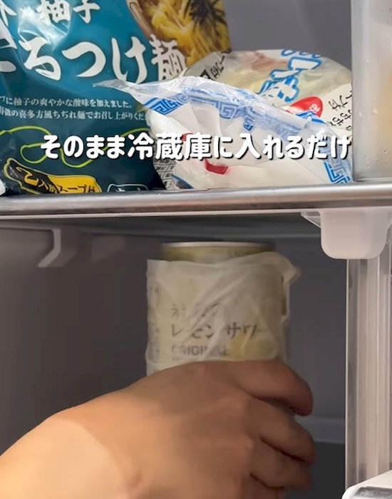 濡らしたキッチンペーパーを巻いた缶飲料を冷蔵庫へ入れている様子