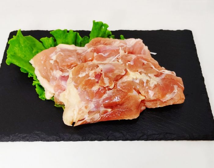 皿に盛りつけられた鶏もも肉とレタスの写真