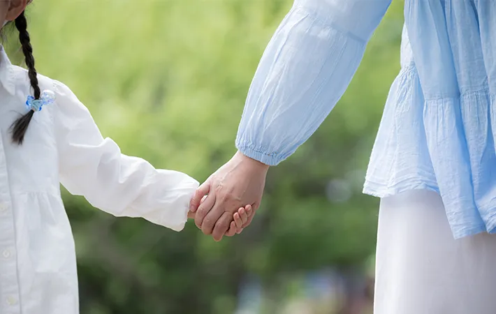 手をつなぐ親子の写真