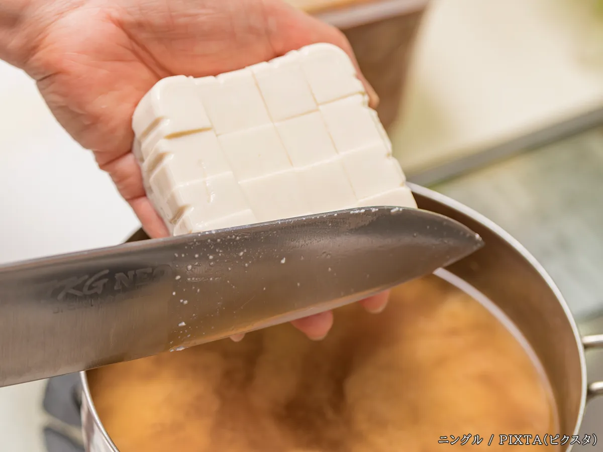 味噌汁に豆腐を入れる写真