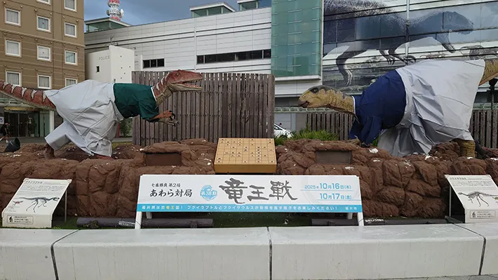 将棋を指す恐竜モニュメントの写真