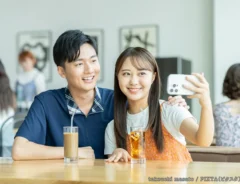 カフェで写真を撮るカップルの写真