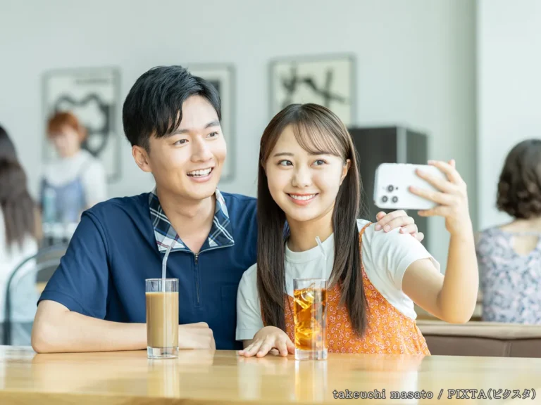 カフェで写真を撮るカップルの写真