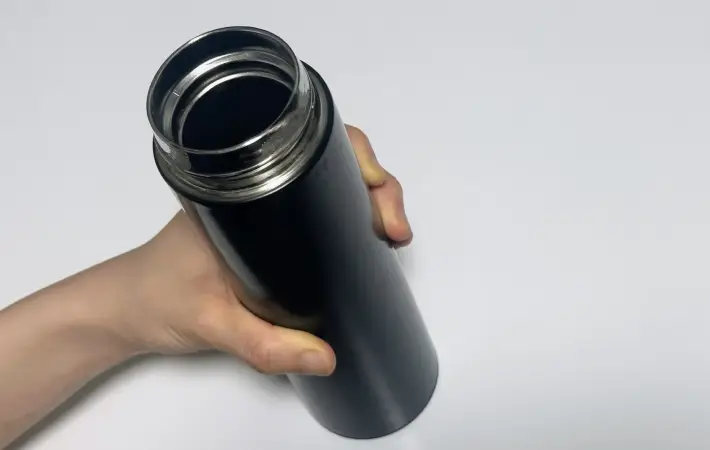 黒い水筒を持つ人
