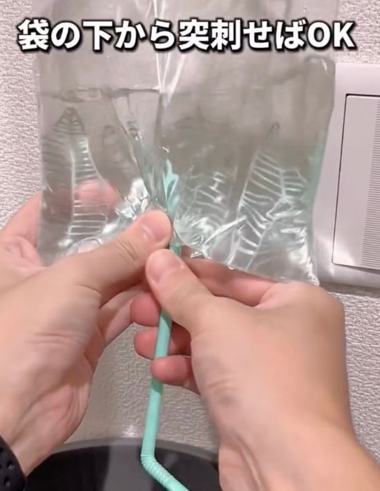 ストローのとがった部分を水を入れたフリーザーバッグに刺した様子
