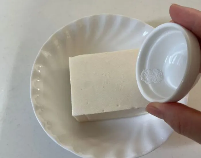豆腐に塩を振る　撮影：grape編集部