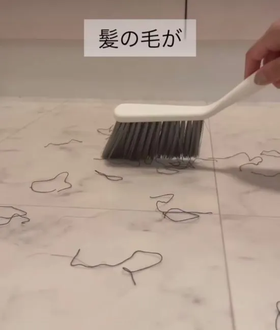 ほうきで床をなでる様子