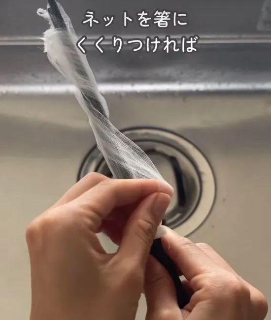 箸に排水口ネットを巻きつける様子