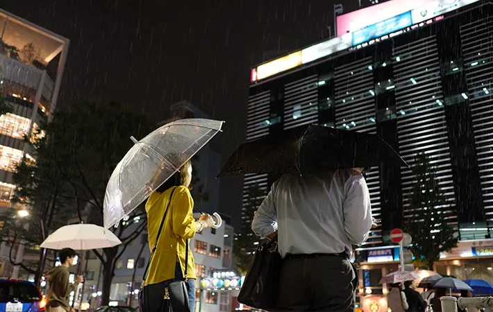 夜の街で傘をさす人の写真