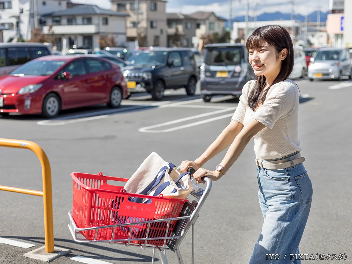 駐車場でカートを押す女性の写真