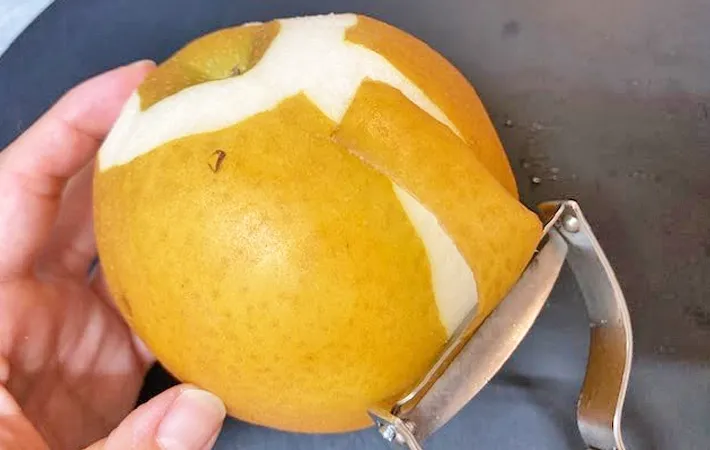 『ピーラーで梨の皮を剥いている』写真（撮影：エニママ）