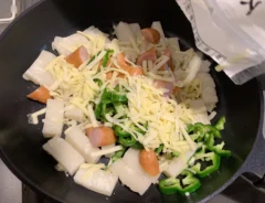 フライパンの中にピザ用チーズを投入している写真（撮影：grape編集部）