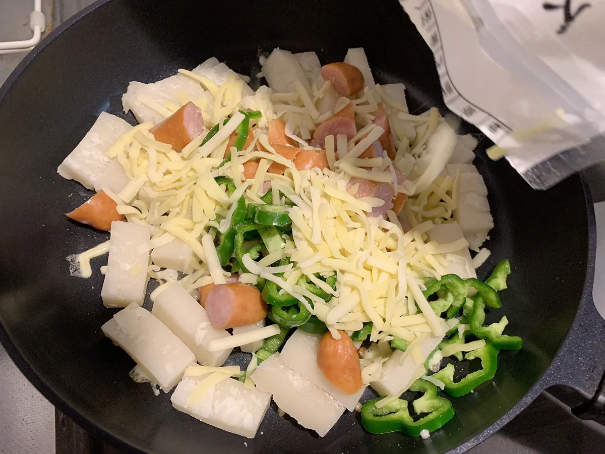 フライパンの中にピザ用チーズを投入している写真（撮影：grape編集部）