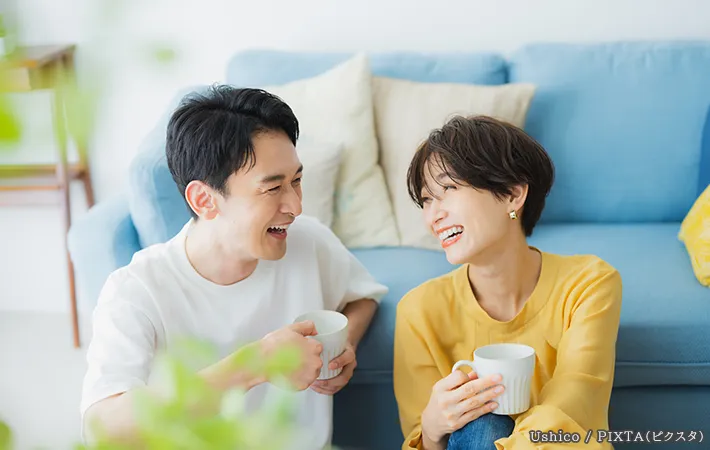 リビングで笑っているカップルの写真