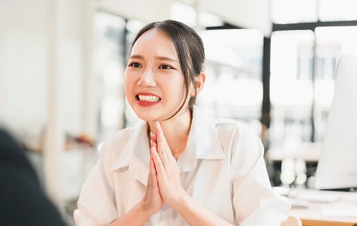 謝る女性の写真