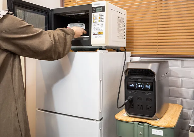 DELTA 3 Plusに繋いだ電子レンジを使う女性の写真
