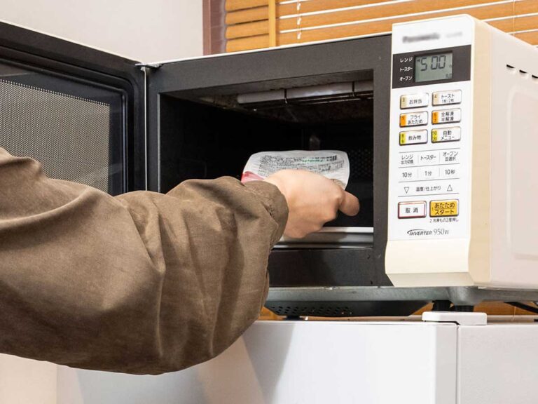 電子レンジでご飯を温める女性