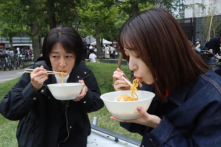 ラーメンをすする女性たちの写真（撮影：grape編集部）