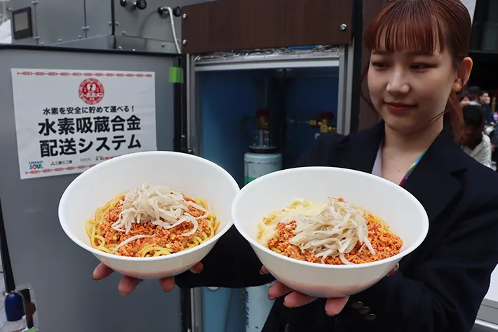 ラーメンを手にする女性の写真（撮影：grape編集部）