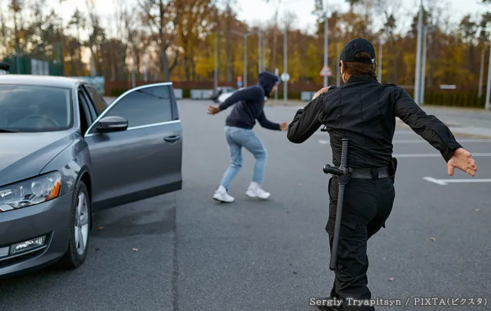 男性を追いかける警察官の写真