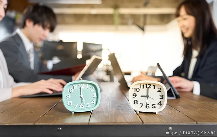 仕事をしている人と時計の写真