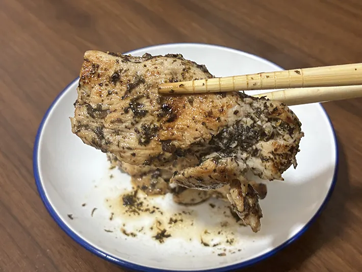 箸でつまむ『むね肉のマヨゆかり炒め』の写真（撮影：grape編集部）