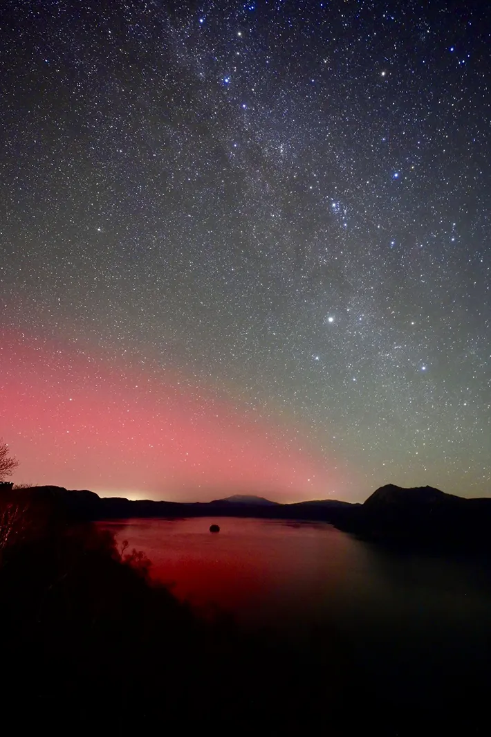 湖の上で観測されたオーロラと、天の川の写真