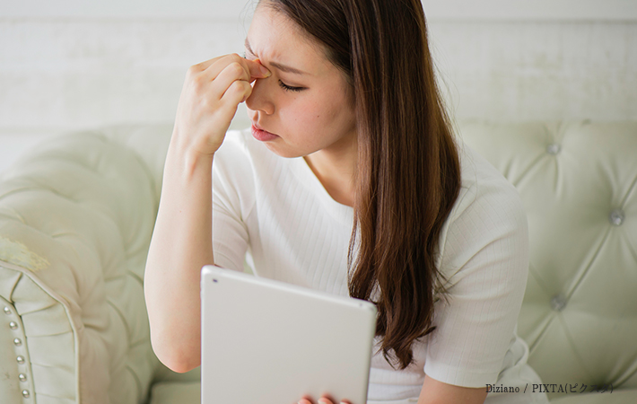 目頭を押さえている女性の画像